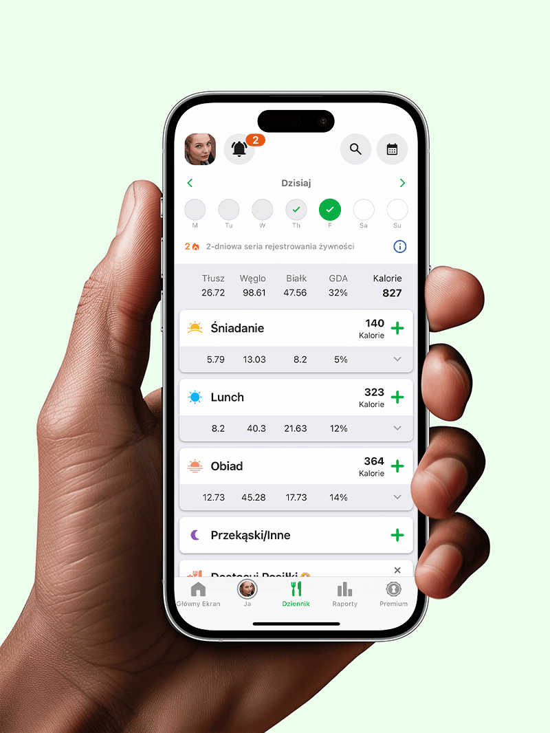 Man's hand holding mobile phone that shows fatsecret app diary screen showing food logged against breakfast and lunch.